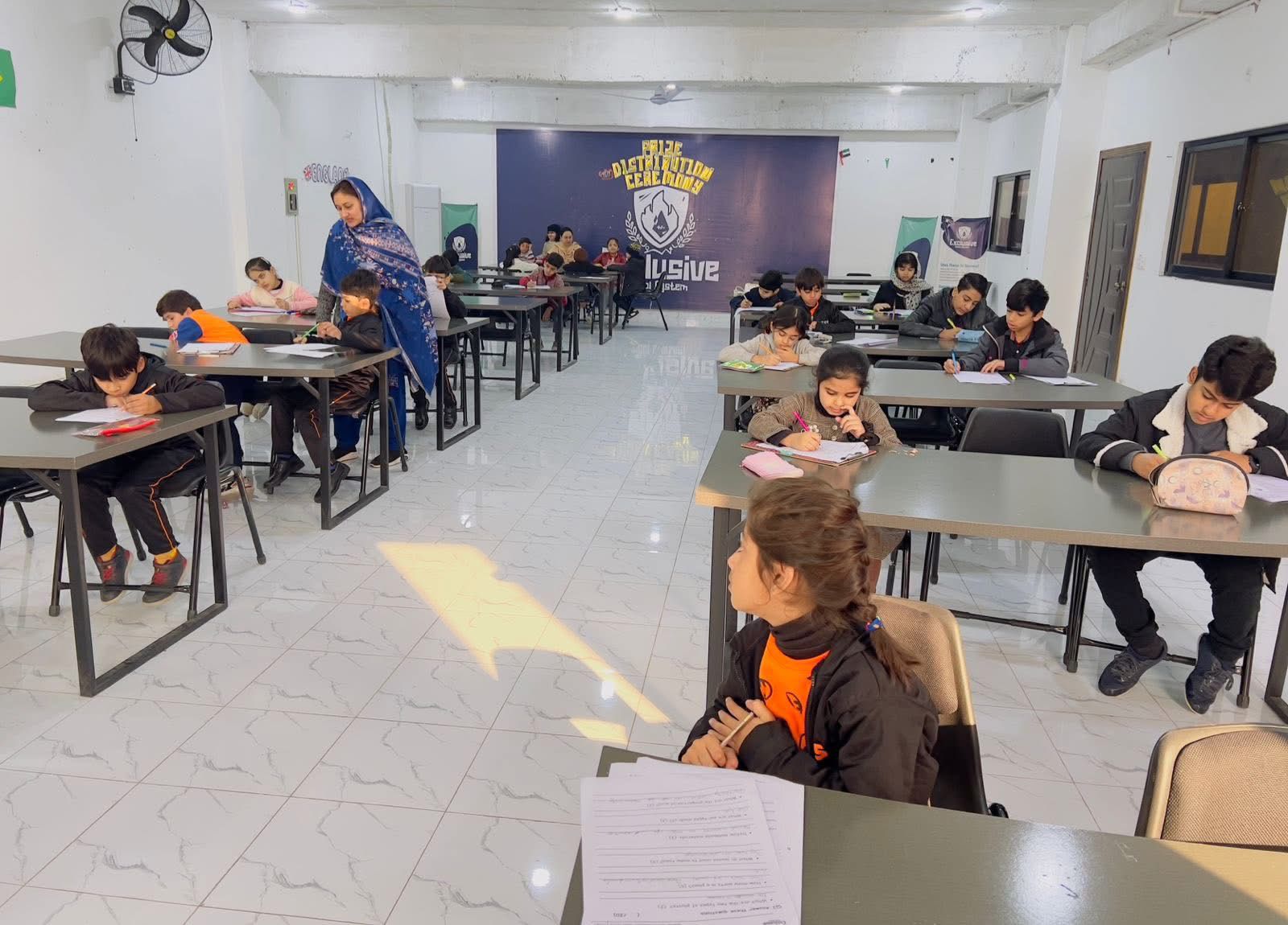 Students studying in classroom with teacher supervision